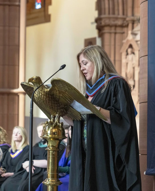 Vice Principal delivering a speech at the podium during the graduation ceremony inside a church Vice Principal delivering a speech at the podium during the graduation ceremony inside a church